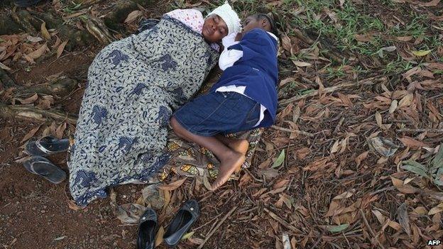 Hanah Siafa lies with her daughter Josephine, 10, while hoping to enter the new Doctors Without Borders (MSF), Ebola treatment centre on 17 August 2014 in Monrovia, Liberia