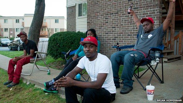 Ferguson, Missouri, residents sit in front of an apartment complex near where Michael Brown was shot