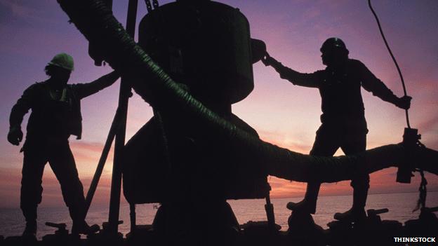 Oil workers in silhouette