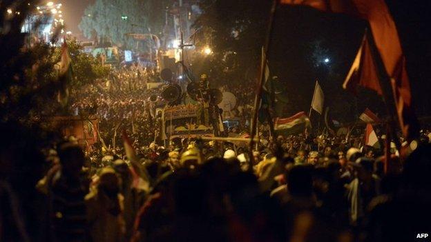 Supporters of Canada-based preacher Tahir-ul-Qadri march towards the parliament as they take part in an anti-government demonstration in Islamabad, 19 August 2014