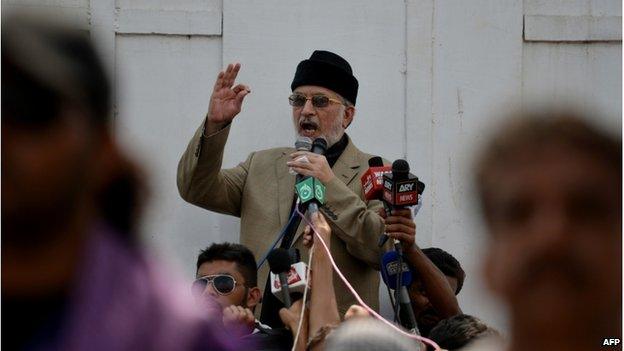 Canada-based preacher Tahirul Qadri is surrounded by Pakistani supporters as he addresses demonstrators in front of the Parliament during the "Revolution March" protest in Islamabad on 20 August 2014.