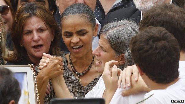 Brazilian politician Marina Silva grabs the hand of Renata de Andrade Lima, widow of late presidential candidate Eduardo Campos, during the wake at the Pernambuco Government Palace in Recife on 17 August, 2014