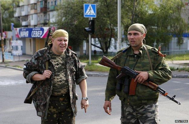 Rebels patrolling a street in Makiika, near Donetsk, 19 August