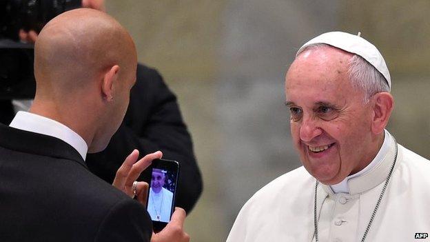 A San Lorenzo player takes a picture of Pope Francis, before his general audience in the Paul VI hall at the Vatican on 20 August, 2014.