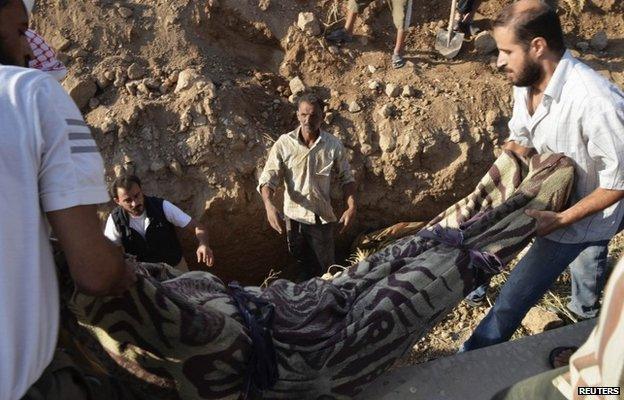 Men bury a victim of the 21 August chemical weapons attack in Damascus