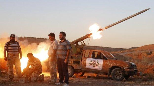 Free Syrian Army fighters launch a rocket