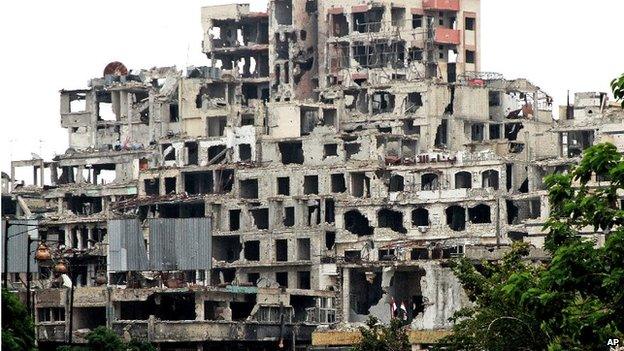 Syrian government officials survey the damage in the old city of Homs - 8 May 2014