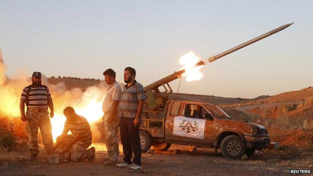 Free Syrian Army fighters launch a rocket