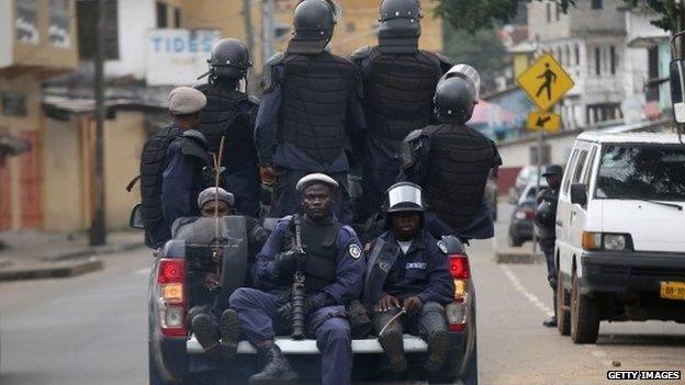 Members of Liberia's Ebola Task Force ride in the back of a pickup as they enforce a quarantine on the West Point slum on 20 August 2014 in Monrovia, Liberia