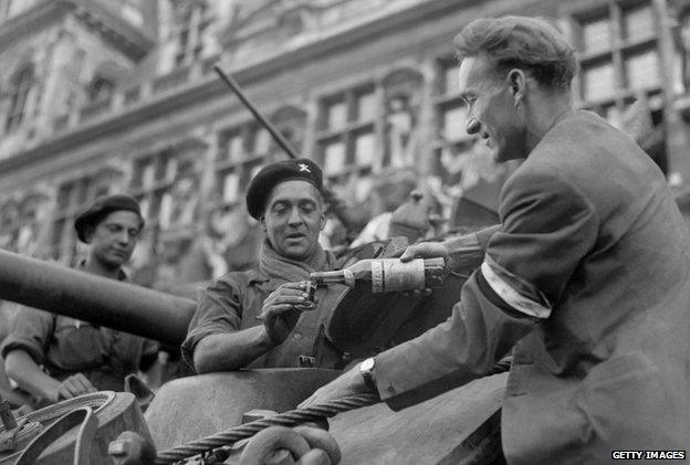 Parisian gives a French soldier a glass of cognac (25 August 1944)