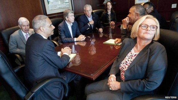 US Attorney General Eric Holder (bottom L) attends a meeting at the US Attorney's office in St Louis, Missouri 20 August 2014