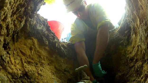 Workman installing water meter - view from inside the hole