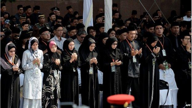 Family members and next-of-kin of the Malaysia Airlines flight MH17 victims pause for a moment of silence during a ceremony in the Bunga Raya complex at Kuala Lumpur International Airport in Sepang on 22 August 2014.