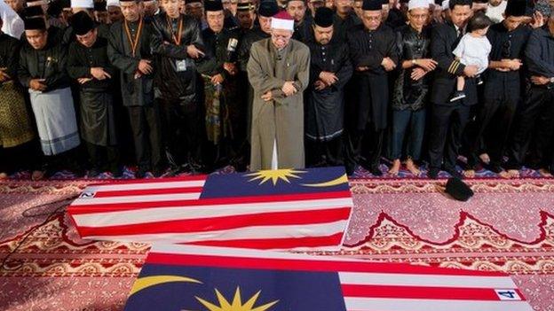 Malaysian Muslim and family members offer special prayers for the remains of co-pilot Ahmad Hakimi Hanapi (L) and flight attendant Nur Shazana Mohamed Salleh (R), the Malaysians who perished aboard flight MH17 that was downed in eastern Ukraine at a mosque in Putrajaya, outside Kuala Lumpur on 22 August 2014