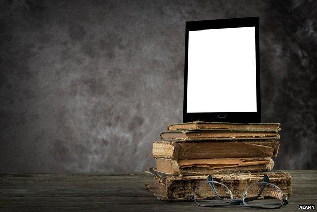 Tablet propped up on top of old books