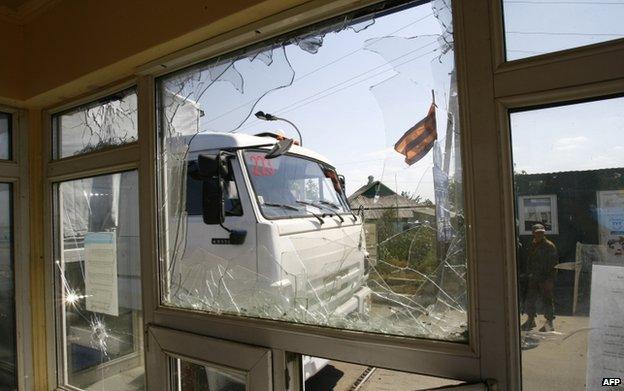 A Russian aid lorry enters Ukraine, passing a rebel sentry, 22 August