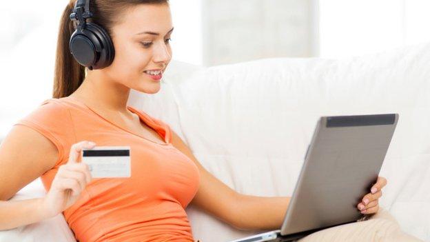 Woman listening to music while making online purchase