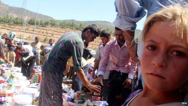 Yazidi refugees receiving humanitarian aid near Dohuk city