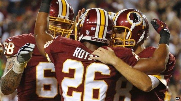 Washington Redskins tackle Tom Compton (68) and quarterback Kirk Cousins (8) celebrate with running back Evan Royster (26), after Royster's touchdown during the first half of an NFL preseason football game 18 August 2014