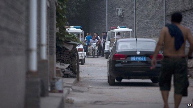 Chinese policemen and men claiming to be villagers block an alleyway leading to the venue for the Beijing Independent Film Festival on 23 August 2014