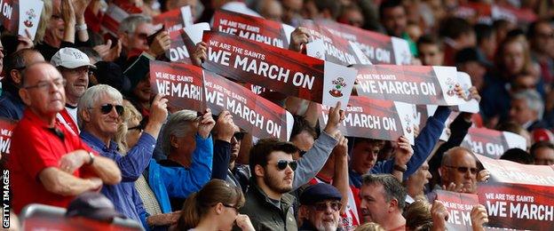 Saints fans hold up signs during the Barclays Premier League match between Southampton and West Bromwich Albion