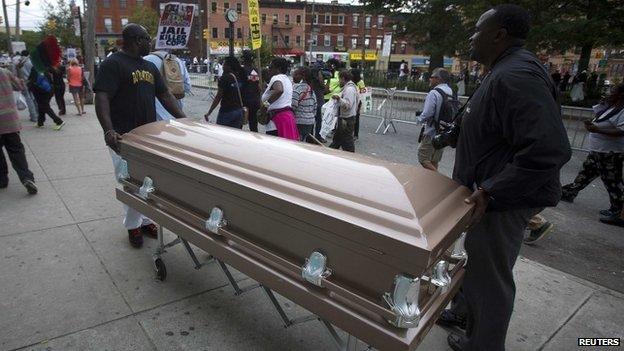 People wheel a coffin on the street as they take part in the "We Will Not Go Back" march and rally for Eric Garner in the Staten Island borough of New York August (23 August 2014)