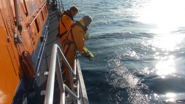 RNLI putting wreath in sea