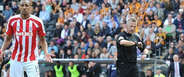 Referee Jonathan Moss checks the goal line technology on his watch before awarding a goal to Stoke City's Ryan Shawcross