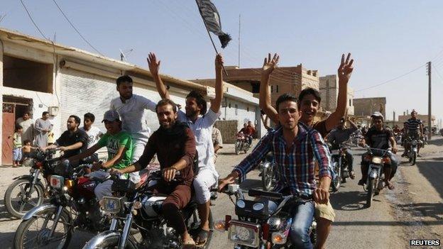 Residents of Tabqa city tour the streets on motorcycles, carrying flags in celebration after Tabqa air base fell