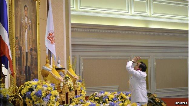 Thailand's newly appointed Prime Minister Prayuth Chan-ocha pays his respects as he receives the royal endorsement, in front of a portrait of Thai King Bhumibol Adulyadej, at the Royal Army headquarters in Bangkok in this 25 August 2014 handout photo provided by the Thailand Government House