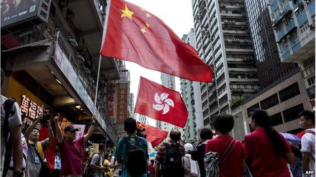 People hold the Chinese and Hong Kong flags as they take part in a pro-government rally in Hong Kong on 17 August 2014