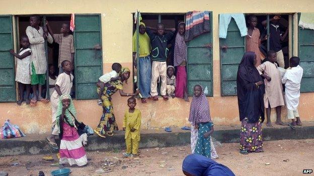 A picture taken on August 21, 2014 shows Internally Displaced People (IDP) standing outside a classroom they found shelter in, at Gulak camp in Nigeria"s northeastern Adamawa State.