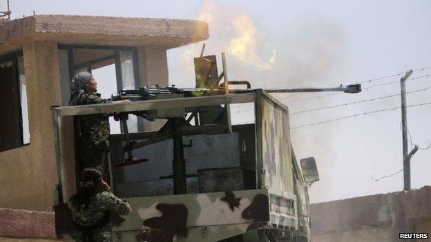 Members of the Syrian Kurdish Popular Protection Units (YPG) fire a heavy weapon towards Islamic State fighters on the Syria-Iraq border (5 August 2014)