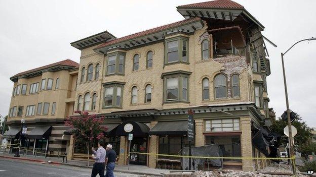 Two men walk past the earthquake-damaged building that housed the Carpe Diem wine bar Napa, California 25 August 2014