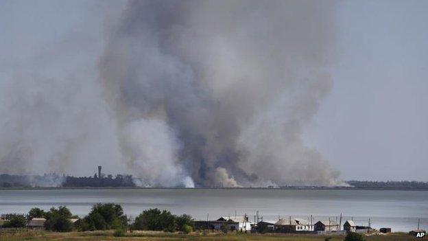 Smoke rises close to the town of Novoazovsk, 26 Aug