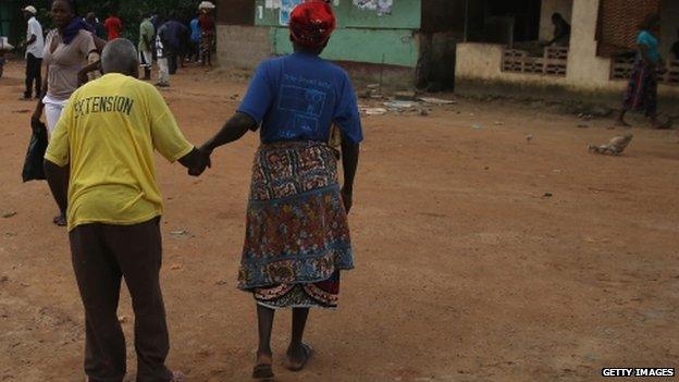 People walk through the streets of Dolo Town, Liberia, which has been quarantined because of the Ebola outbreak - 23 August 2014