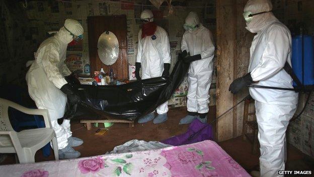 A team helps dispose of a person who died of Ebola in Liberia - August 2014