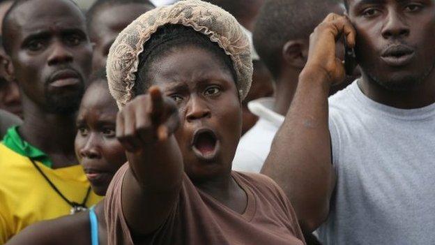 Angry people quarantined in the West Point township in Liberia's capital, Monrovia, wait for relatives to deliver them food and personal items - 23 August 2014