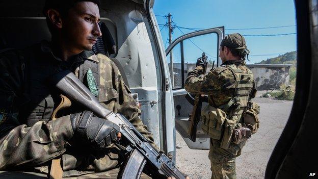 Pro-Russian rebels stand guard at the vehicle used for transportation of mobile military groups in Petrovskiy district in the town of Donetsk, eastern Ukraine