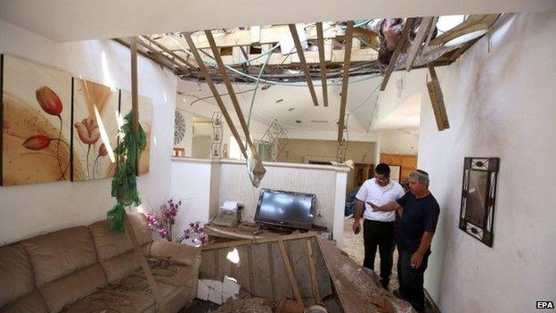 Israelis inspect damage to a house in the southern town of Ashkelon (26 August 2014)