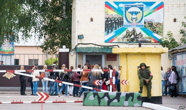 Mothers and wives of Russian paratroopers stand near a checkpoint in Kostroma, north of Moscow