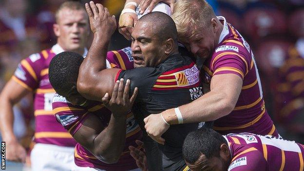 Catalan's Lopini Paea is tackled by Huddersfield's Jermaine McGillvary, Aaron Murphy & Ukuma Ta'ai