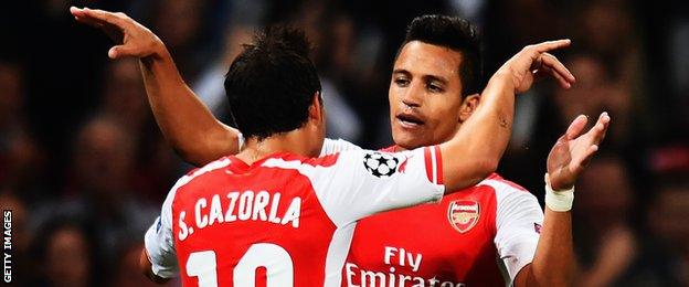 Alexis Sanchez celebrates with team mate Santi Cazorla of Arsenal after scoring during the UEFA Champions League Qualifier 2nd leg match between Arsenal and Besiktas