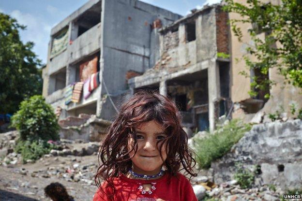 Aysha, 5, stands outside an abandoned building in Istanbul that has been her home for half a year