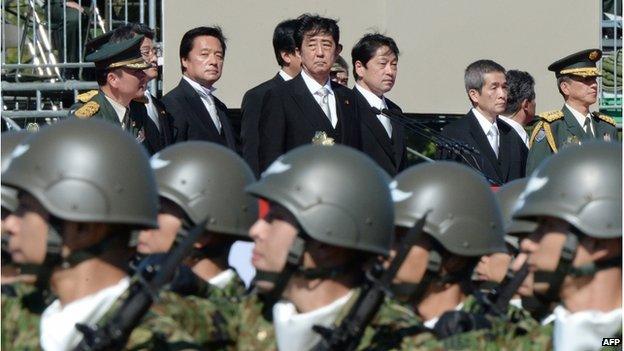 This file picture taken on 27 October 2013 shows Japanese Prime Minister Shinzo Abe (top centre) inspecting troops of Japan's Self-Defence Force during a military review at the Ground Self-Defence Force"s Asaka training ground, suburban Tokyo