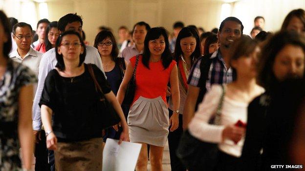 Commuters walk inside the Raffles Place MRT station during rush hour at the central business district area on 13 February 2013 in Singapore