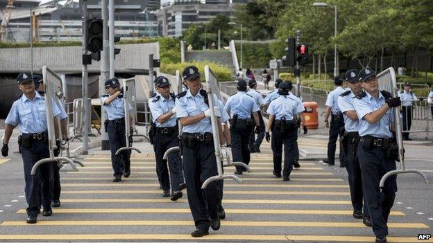 Police officers carry barriers outside Hong Kong government offices