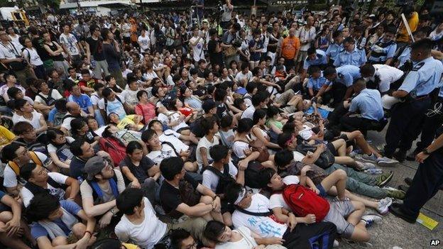 Protesters are taken away by police officers in Hong Kong (image from 2 July)