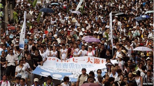 Protesters hold a banner which reads "2014 July 1 mass march" to demand universal suffrage in Hong Kong on 1 July 2014, the day marking the 17th anniversary of the territory's handover to China.