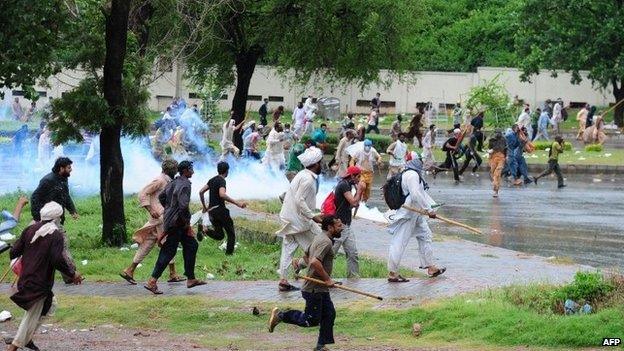 Pakistani opposition protesters run towards police during clashes near the prime minister"s residence in Islamabad on September 1, 2014.